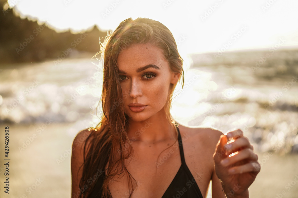 Beauty portrait of sexy girl on the beach, posing during sunset time. Beautiful Model Woman.