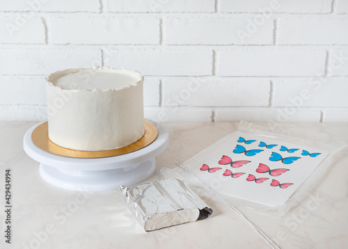 ingredients for decorating white cake with red and blue butterflies