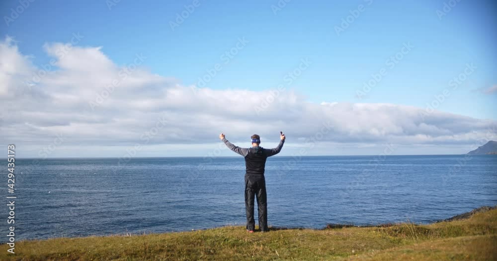 Caucasian man standing near cliff with ocean in background, Iceland Caucasian man standing near cliff with ocean in background, Iceland