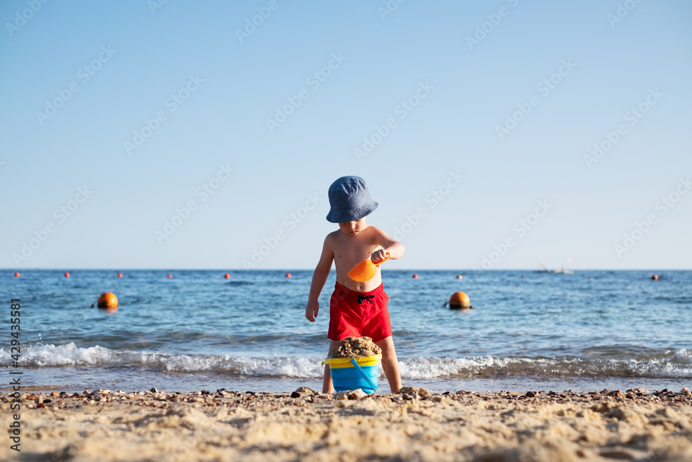 Boy kid in red shorts on the summer beach Boy kid in red shorts on the summer beach