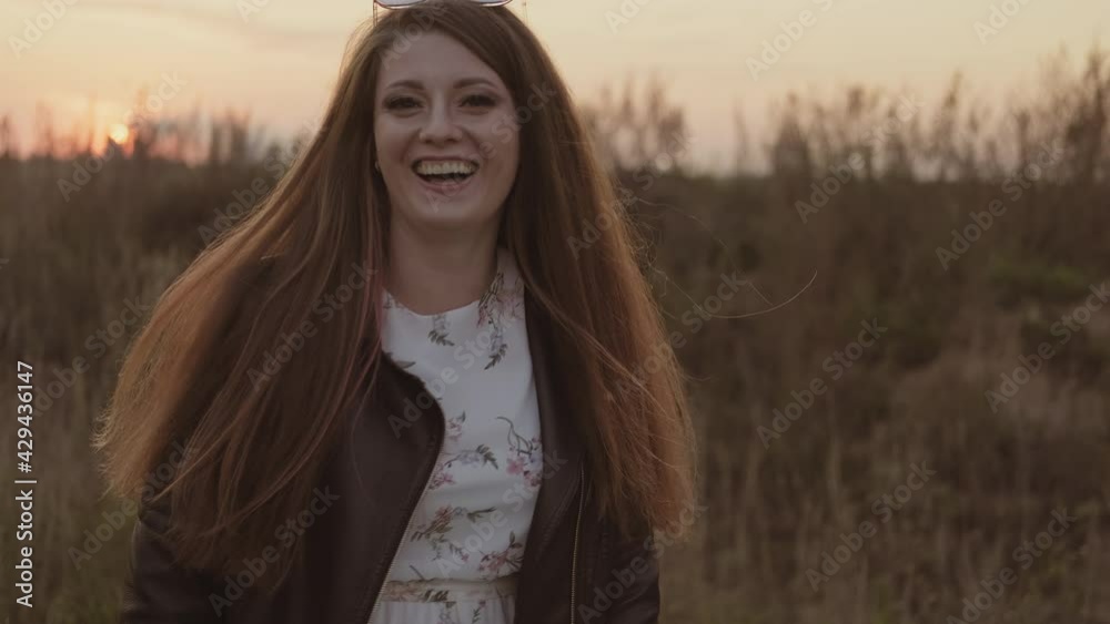 Young woman happily walking during sunset outdoors. Beautiful carefree woman enjoying nature. Harmony. 4K, UHD Young woman happily walking during sunset outdoors. Beautiful carefree woman enjoying nature. Harmony. 4K, UHD