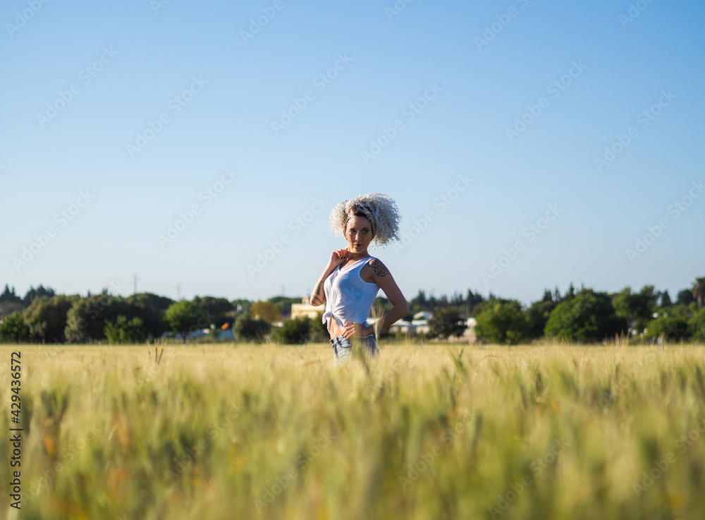 Mujer joven con pelo blanco en un campo de trigo Mujer joven con pelo blanco en un campo de trigo