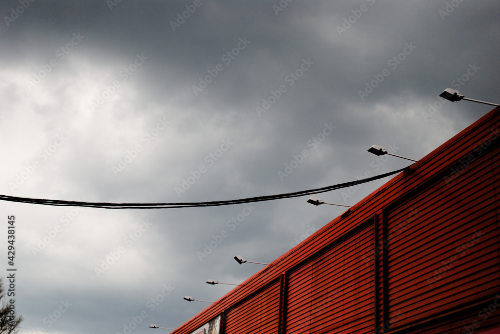 shopping mall wall and street lights against stormy sky shopping mall wall and street lights against stormy sky