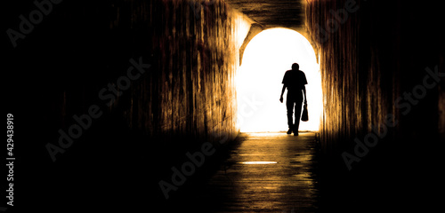 Old Man Walking Through Tunnel
