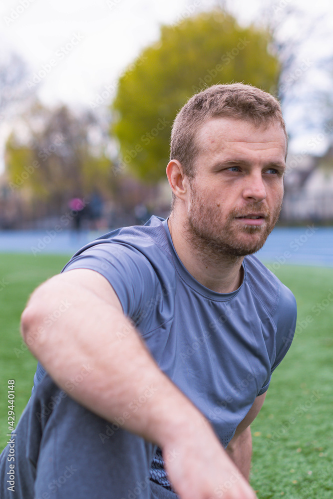 Fit man relaxing in a park setting, healthy lifestyle 