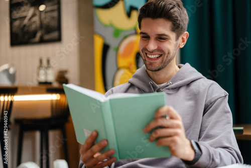 Smiling young man reading book