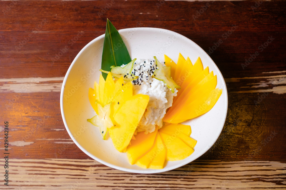 Dessert with mango and rice. Pan-Asian oriental cuisine on wooden table. Dessert with mango and rice. Pan-Asian oriental cuisine on wooden table.