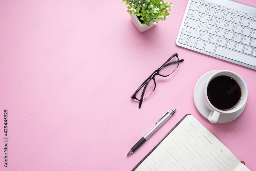 Pink office desk with keyboard, glasses, coffee mug are placed at office. Copy space. Pink office desk with keyboard, glasses, coffee mug are placed at office. Copy space.