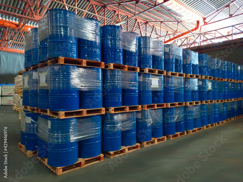 Many blue buckets are stacked on top of each other. In warehouse