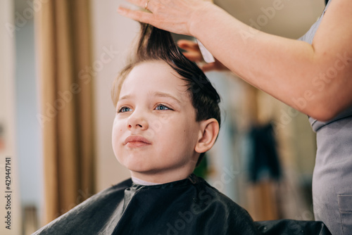 Haircut for little kid boy, professional barber doing haircut. Hairdress for children