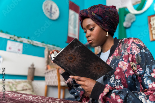 Black Muslim Woman studying in blue room