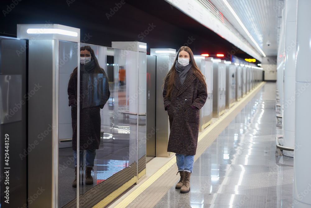 custom made wallpaper toronto digitalWoman in a medical face mask is standing near the departing train on the subway.