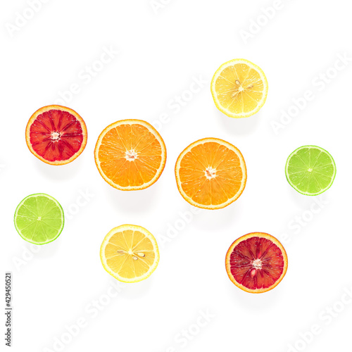 Various citrus fruits cut in half isolated on white background. Top view.