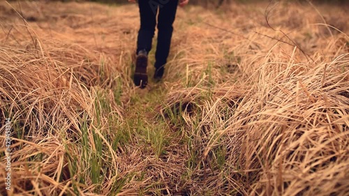 Wallpaper Mural black fashionable massive brutal boots with mud swamp on the soles leave on dry grass. girl woman in black clothes and black shoes walks on brown grass.  Torontodigital.ca