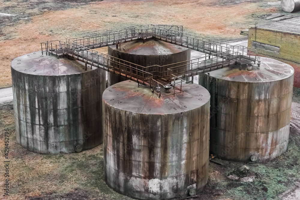Old fuel oil tanks with smudges of fuel oil in an abandoned industrial plant Old fuel oil tanks with smudges of fuel oil in an abandoned industrial plant