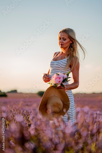 Mujer rubia con sombrero en campo de lavanda