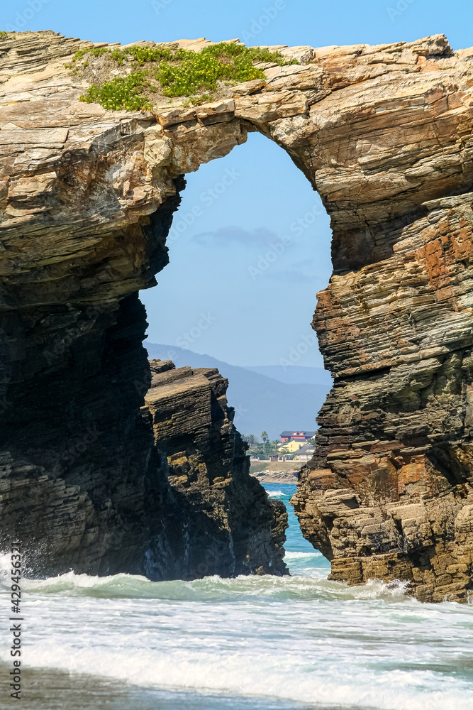 Large stone arch on the seashore, in the famous beach of the cathedrals in Galicia Spain.