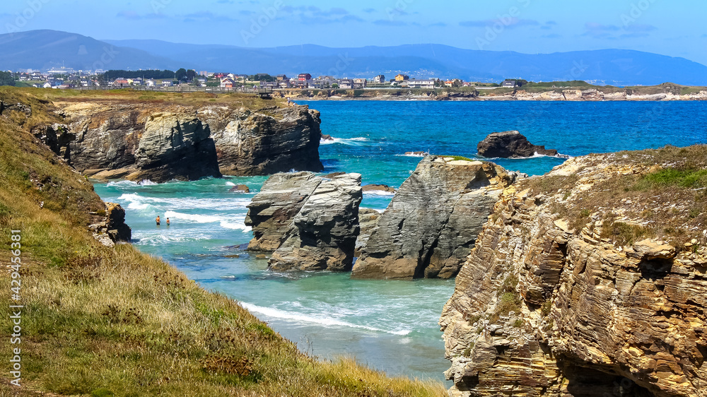 Aerial view of Las Catedrales beach with summer houses in the background along the seashore. Galicia.