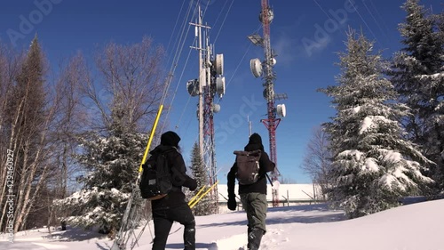 Adventurous video showing two young documentarians looking at the marvels of cellular signals towers, situated in a snow capped hilltop. photo