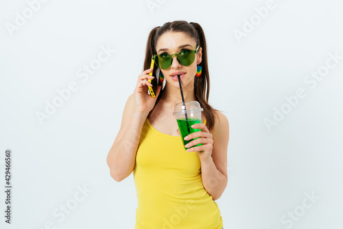 Young woman with two tails hairstyle in summer yellow top and green sunglasses