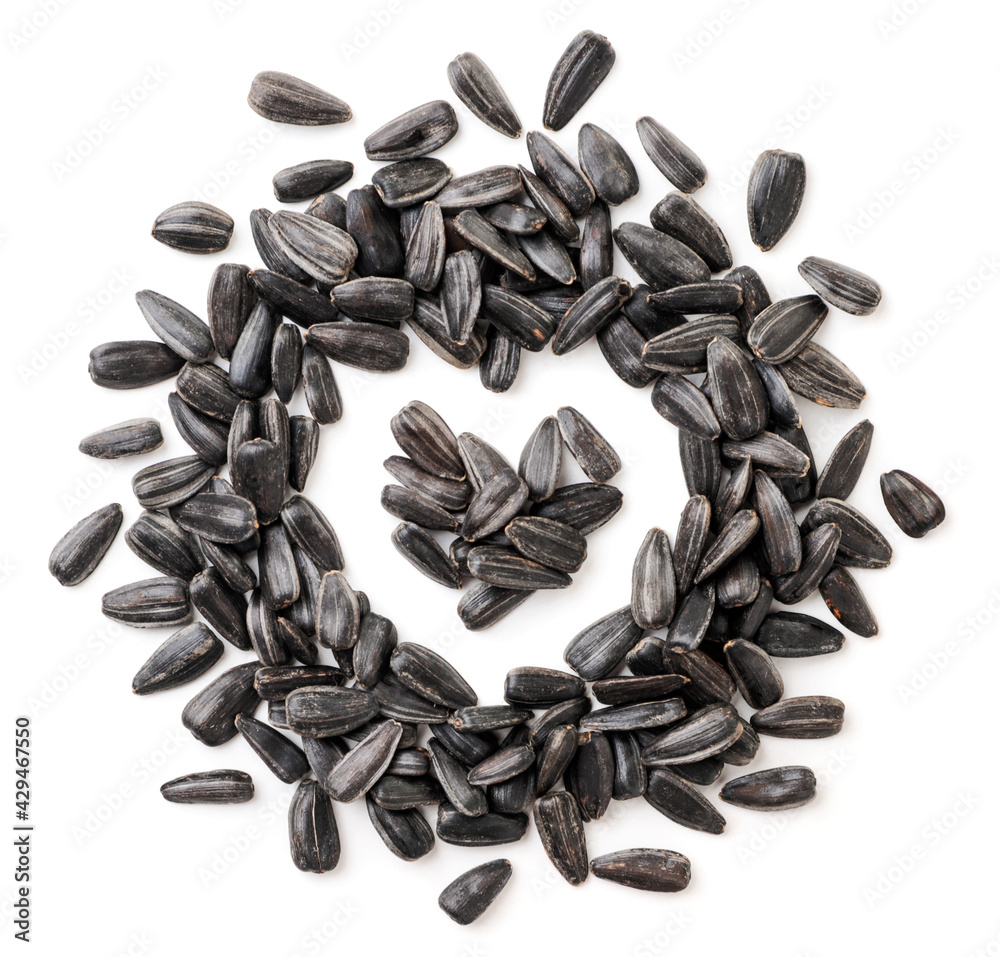 Unpeeled sunflower seeds in the shape of a heart on a white background, isolated. Top view Unpeeled sunflower seeds in the shape of a heart on a white background, isolated. Top view