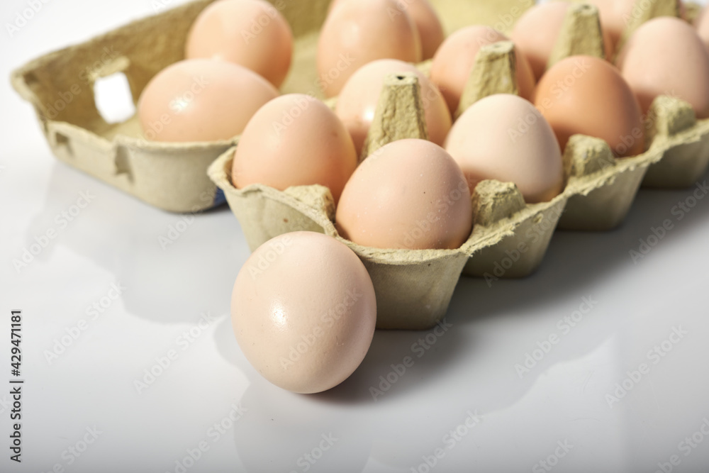 Close-up of eggs in cartoon on white background. Raw chicken eggs in egg box organic food for good health high protein . Close-up of eggs in cartoon on white background. Raw chicken eggs in egg box organic food for good health high protein .