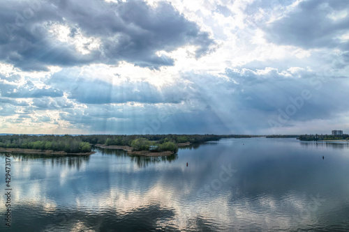  Light of the setting sun through the clouds. River and sky © konoplizkaya