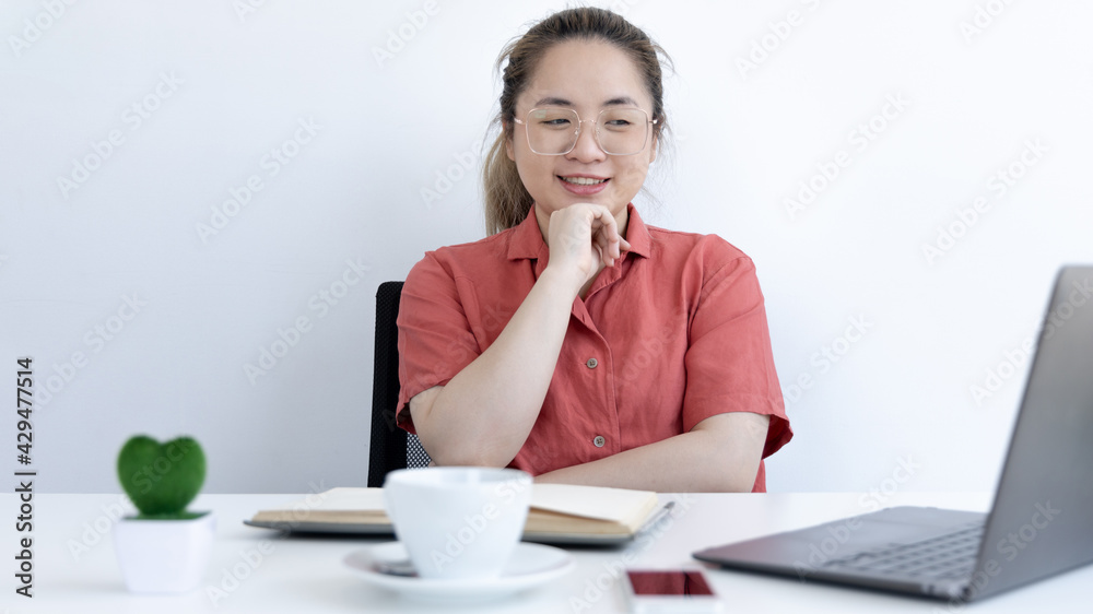 Asian business woman in a bright t-shirt is working at home, Stay home, New normal, Covid-19 coronavirus, Social distancing, Coming up with ideas for work, Writing information in a notebook. Asian business woman in a bright t-shirt is working at home, Stay home, New normal, Covid-19 coronavirus, Social distancing, Coming up with ideas for work, Writing information in a notebook.