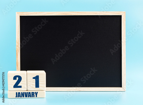 January 21. Day 21 of month, Cube calendar with date, empty frame on light blue background. Place for your text. Winter month, day of the year concept