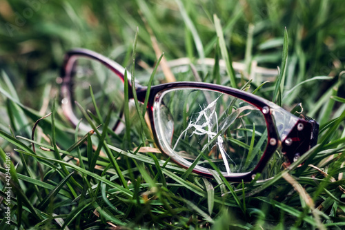 Fototapeta Naklejka Na Ścianę i Meble -  Broken glasses lie in the grass. An accident