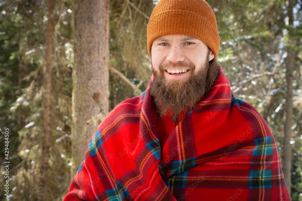 Portrait of happy young man with beard in snowy forest. Smiling man with beard in winter time. Winter mood. Sport man hiking in mountains. Portrait of happy young man with beard in snowy forest. Smiling man with beard in winter time. Winter mood. Sport man hiking in mountains.