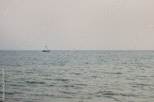 A small blue fishing boat sailed in the middle of the sea with.