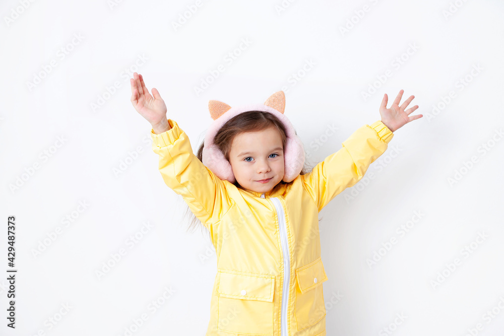 A nice girl in a yellow jacket spread her arms to the sides. Demi-season clothing. Weather in spring and autumn. Portrait on a white background. place for text. A nice girl in a yellow jacket spread her arms to the sides. Demi-season clothing. Weather in spring and autumn. Portrait on a white background. place for text.