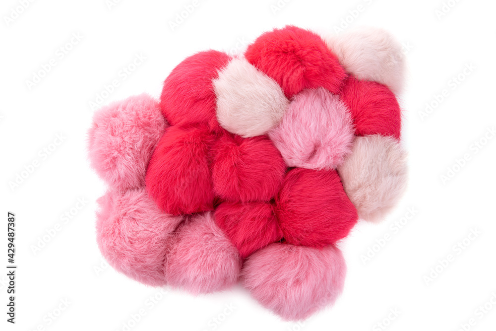 Close up of pink and red rabbit fur pompoms isolated on white background. Top view. Close up of pink and red rabbit fur pompoms isolated on white background. Top view.
