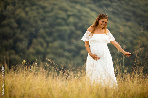 Young pregnant woman at the field