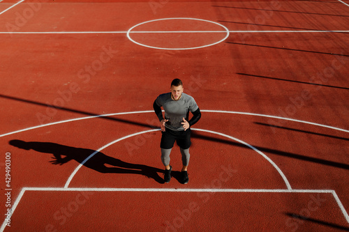 Top view of young athlete man warming up before running outside.
