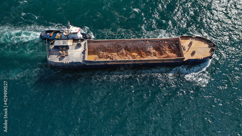 Aerial drone photo of assisted with tug boat barge filled with stones near Mediterranean port © aerial-drone