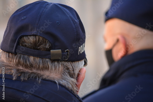 Polski policjant w niebieskim mundurze z napisem policja. 