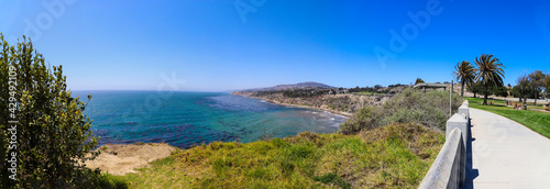 Bild auf Leinwand a panoramic shot of the coast with vast deep blue ocean water and waves crashing