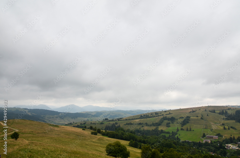 Carpathian mountains with green slopes under low in thick clouds and fog on a cloudy day. Carpathian mountains with green slopes under low in thick clouds and fog on a cloudy day.