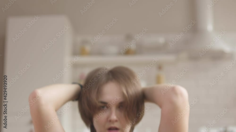 Tired woman doing exersices at home, at her living room. It's difficult for her but she doesn't give up 