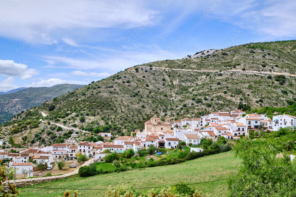 View of white village with mountains to the rear, Alpandeire, Serrania de Ronda, Malaga province, Andalusia, Spain.