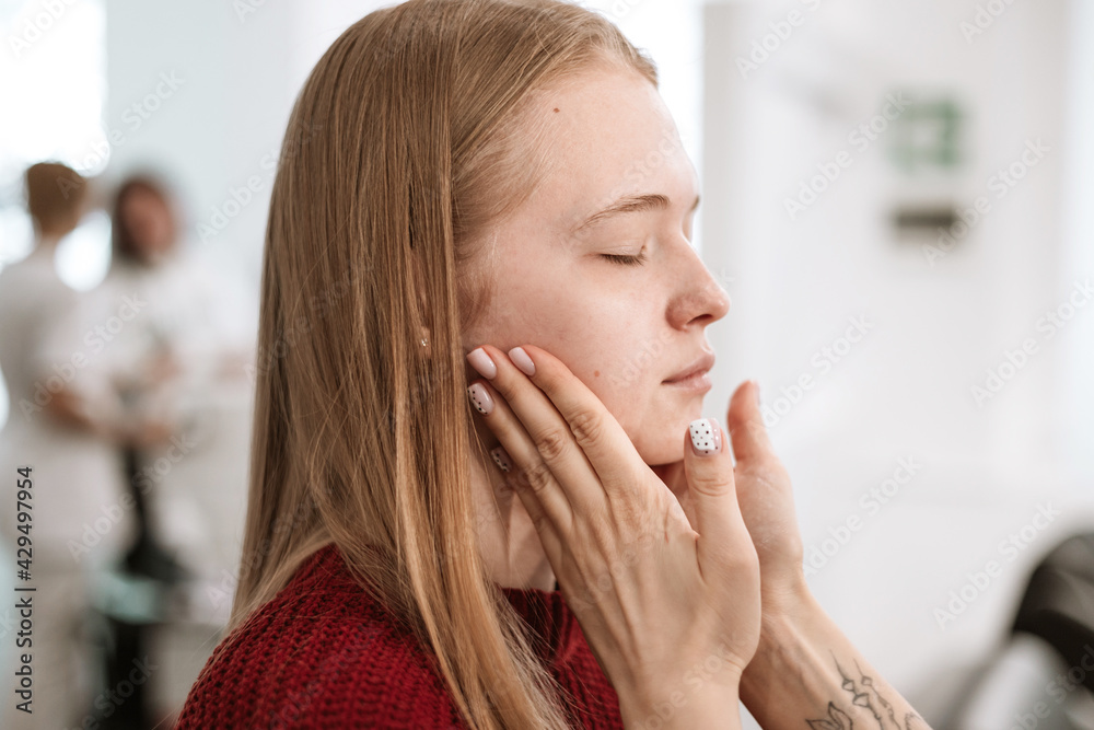 young beautiful blonde woman is sitting near the makeup artist's desk and waiting for makeup, photos before the result young beautiful blonde woman is sitting near the makeup artist's desk and waiting for makeup, photos before the result