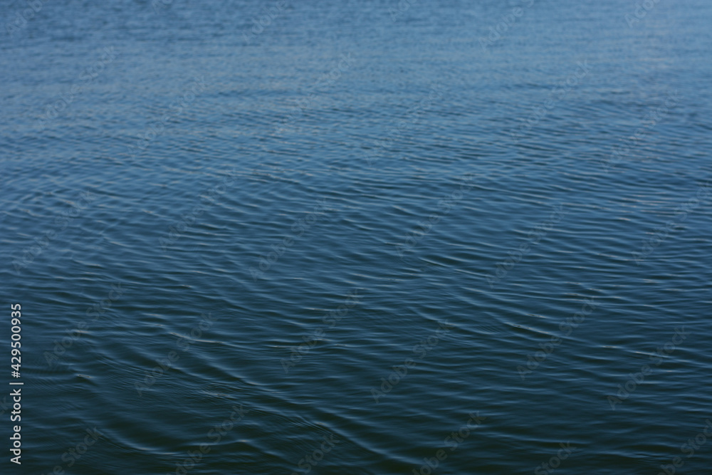 Water drop creating waves and ripples in on a dark blue background Water drop creating waves and ripples in on a dark blue background