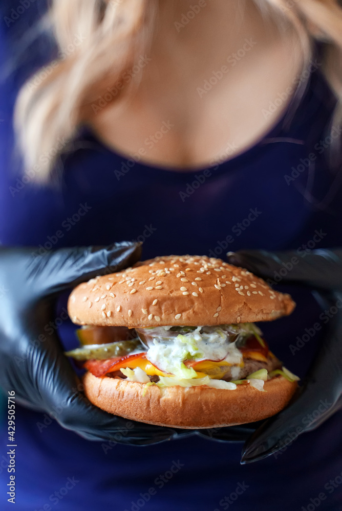 Busty girl holding a hamburger in her hands. Busty girl holding a hamburger in her hands.
