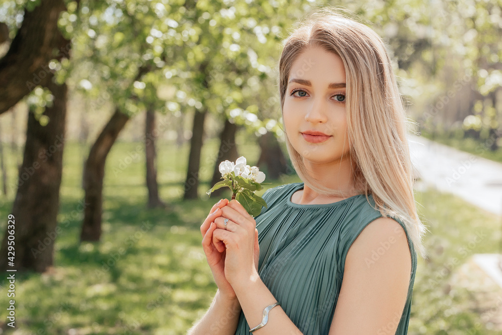Portrait of attractive young blonde woman in spring garden Portrait of attractive young blonde woman in spring garden