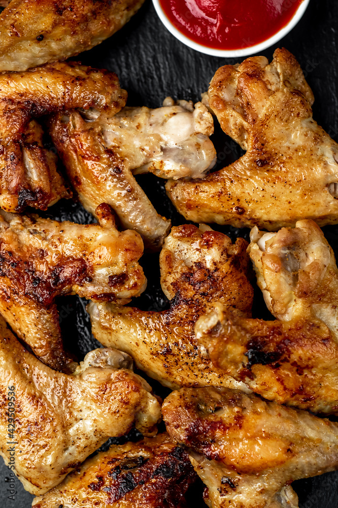 grilled chicken wings with spices on a stone background