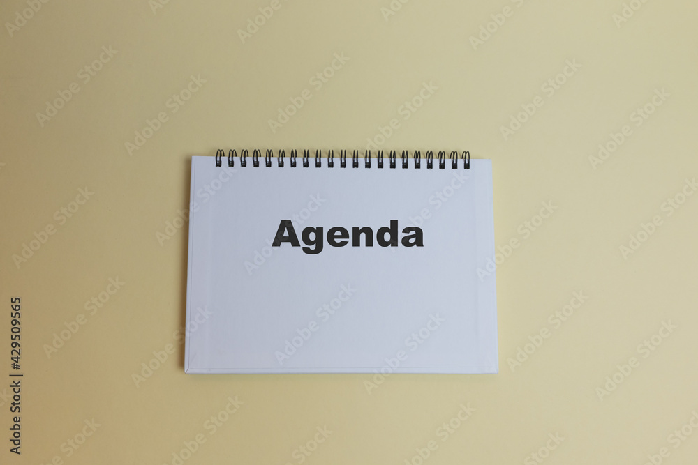 Agenda text on notepad on yellow background. Business motivation, conceptual ideas for inspiration Agenda text on notepad on yellow background. Business motivation, conceptual ideas for inspiration