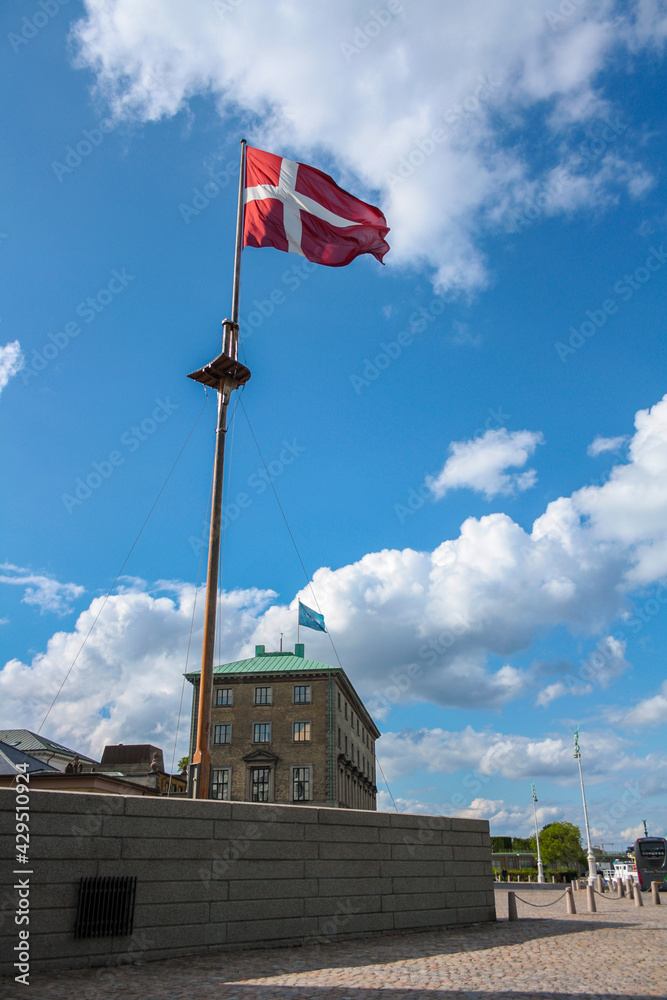 Mast of a ship with the Danish flag blowing in the wind on the Copenhagen waterfront