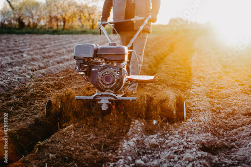 work with a walk-behind tractor in the field of a home farm, plow the soil for sowing. photo